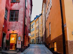 View looking up Gamla Stan Street with red and yellow buildings