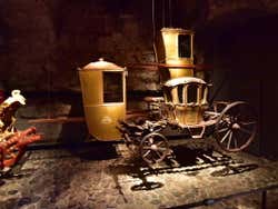 A small Royal carriage in a dark room