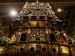 A gold decoration full of sculptures in a museum