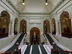 A green hall with stairs leading to different parts of parliament