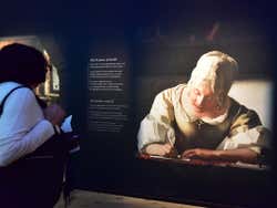 A woman in a white shirt looking at an exhibition
