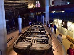 A wooden rowing boat on display in a museum