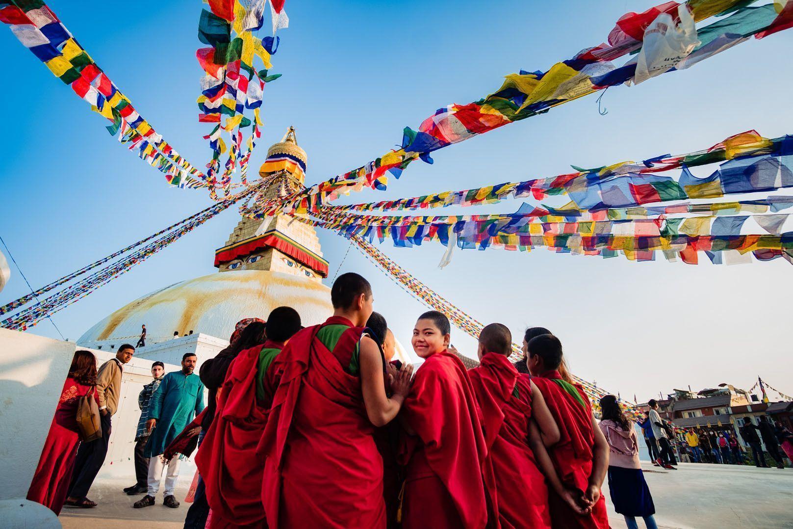 Un gruppo di giovani monaci vestiti di rosso si dirigono verso un tempio in Nepal